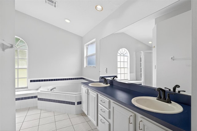 2705 Bayview Dr, Eustis, FL 32726 - bathroom featuring vaulted ceiling, a garden tub, tile patterned flooring, a stall shower, and double vanity