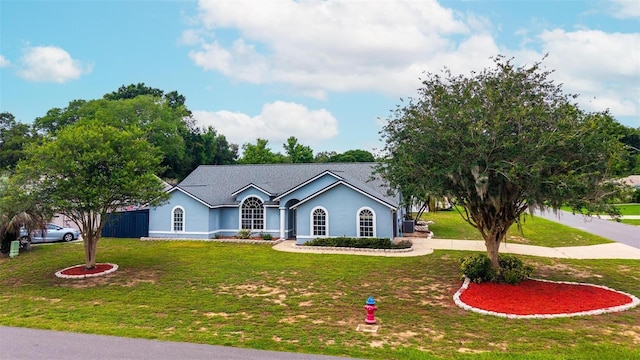 2705 Bayview Dr, Eustis, FL 32726 - ranch-style house featuring a front lawn, stucco siding, and curved driveway