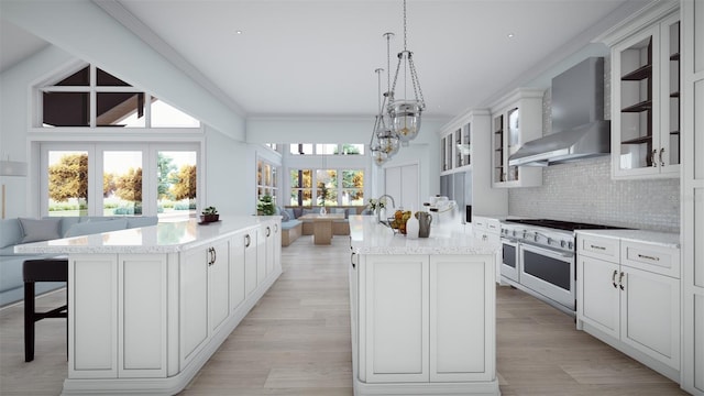 2421 Shady Ln, Groveland, FL 34736 - kitchen featuring a center island, wall chimney range hood, double oven range, plenty of natural light, and ornamental molding