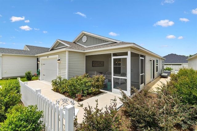 1225 Eunice St, The Villages, FL 34762 - view of front of home with a sunroom, board and batten siding, an attached garage, and roof with shingles