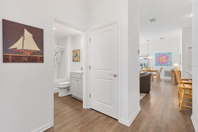 1225 Eunice St, The Villages, FL 34762 - hallway featuring light wood-style floors, baseboards, and a chandelier