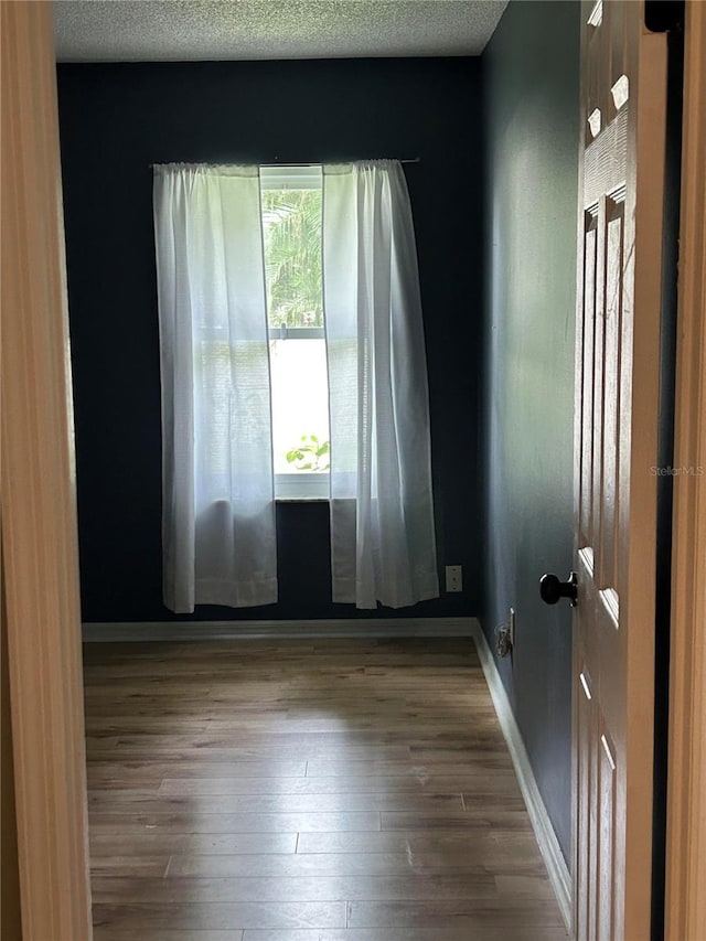 9375 Woodbreeze Blvd, Windermere, FL 34786 - unfurnished room featuring hardwood / wood-style flooring, baseboards, and a textured ceiling