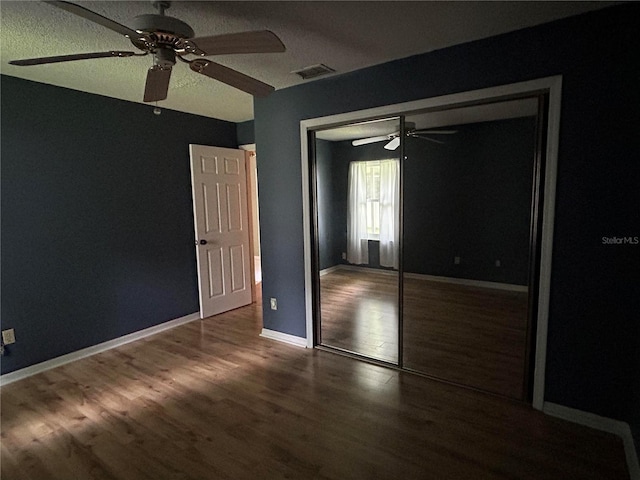 9375 Woodbreeze Blvd, Windermere, FL 34786 - unfurnished bedroom featuring a closet, wood finished floors, a ceiling fan, baseboards, and a textured ceiling