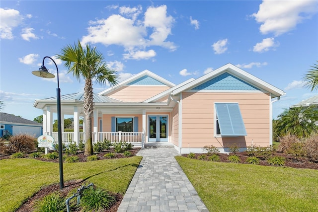 1042 Sugarloaf Key Loop, Lady Lake, FL 32159 - view of front of house featuring a front lawn, covered porch, and french doors