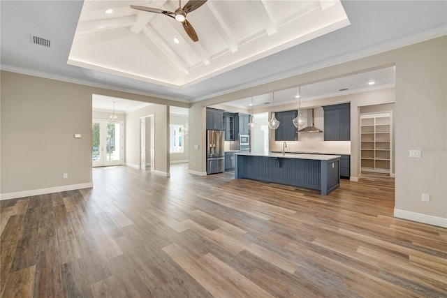 1042 Sugarloaf Key Loop, Lady Lake, FL 32159 - kitchen with wall chimney exhaust hood, appliances with stainless steel finishes, open floor plan, a ceiling fan, and a breakfast bar