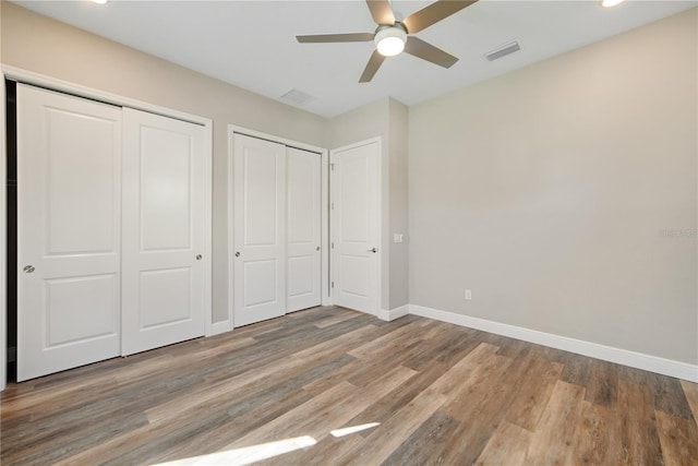 1042 Sugarloaf Key Loop, Lady Lake, FL 32159 - unfurnished bedroom featuring two closets, wood finished floors, recessed lighting, and ceiling fan