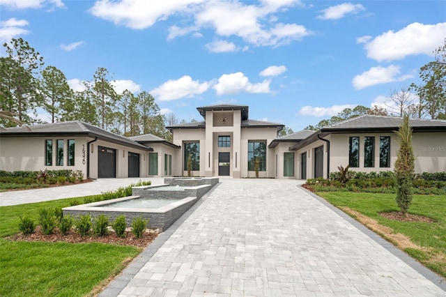 16320 Pendio Dr, Bella Collina, FL 34756 - prairie-style house with an attached garage, stucco siding, decorative driveway, and a front yard