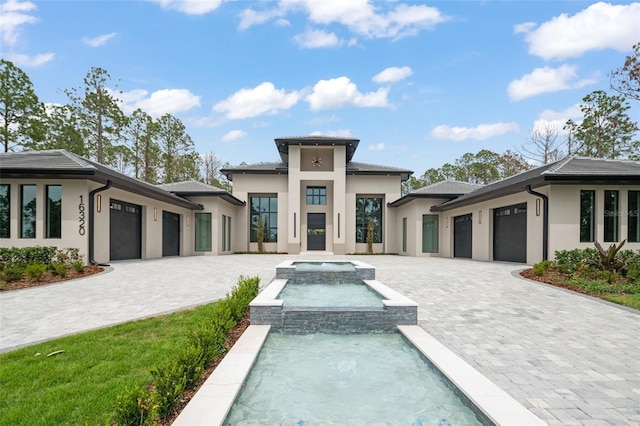 16320 Pendio Dr, Bella Collina, FL 34756 - prairie-style house featuring stucco siding, a garage, and a pool with connected hot tub