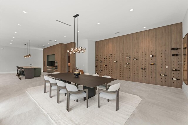 16320 Pendio Dr, Bella Collina, FL 34756 - dining space with recessed lighting, wooden walls, and a chandelier