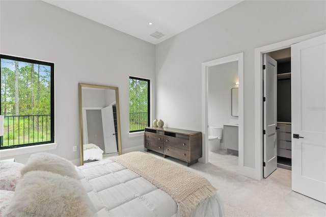 16320 Pendio Dr, Bella Collina, FL 34756 - bedroom with a spacious closet, light carpet, connected bathroom, and baseboards