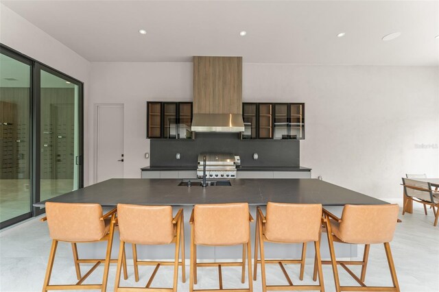 16320 Pendio Dr, Bella Collina, FL 34756 - kitchen featuring dark countertops, wall chimney exhaust hood, range, decorative backsplash, and glass insert cabinets