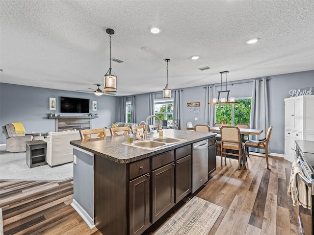 1824 Forest Glen Dr, Fruitland Park, FL 34731 - kitchen with a sink, stainless steel appliances, dark brown cabinets, dark countertops, and wood finished floors