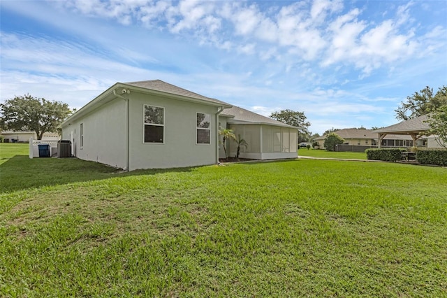 316 Dupont Cir, Howey In The Hills, FL 34737 - rear view of property with central air condition unit, a yard, and stucco siding