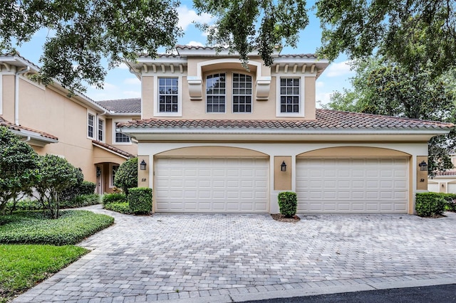 52 Camino Real Blvd, Howey In The Hills, FL 34737 - view of front of house with decorative driveway, a tile roof, stucco siding, and a garage