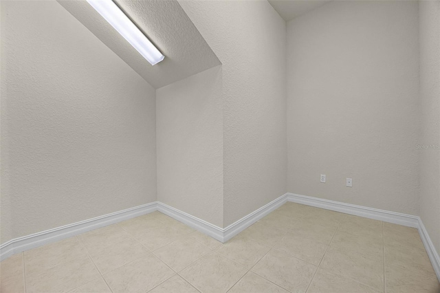 52 Camino Real Blvd, Howey In The Hills, FL 34737 - unfurnished room featuring lofted ceiling, light tile patterned floors, and baseboards