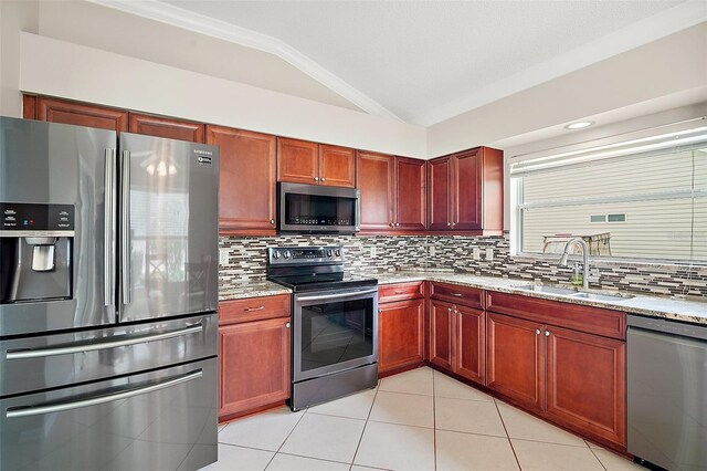 2104 Gerardo Ave, The Villages, FL 32159 - kitchen with stainless steel appliances, a sink, dark brown cabinets, light stone counters, and lofted ceiling