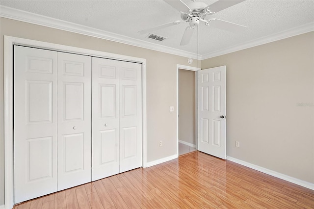 2104 Gerardo Ave, The Villages, FL 32159 - unfurnished bedroom featuring a closet, light wood-style flooring, a textured ceiling, ornamental molding, and baseboards