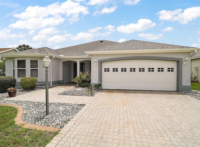 2104 Gerardo Ave, The Villages, FL 32159 - ranch-style house featuring decorative driveway, stucco siding, a garage, and a shingled roof