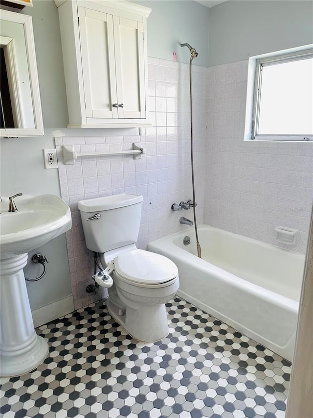 679 Ave Q SE, Winter Haven, FL 33880 - bathroom featuring shower / bathtub combination, tile patterned flooring, and tile walls