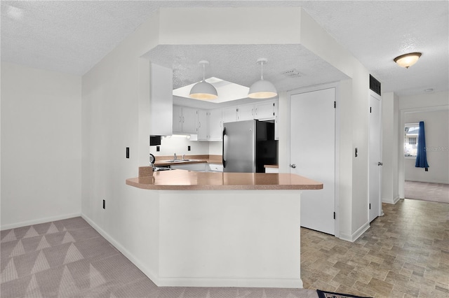 504 Silver Crse Unit A, Ocala, FL 34472 - kitchen featuring freestanding refrigerator, a textured ceiling, baseboards, a peninsula, and light countertops