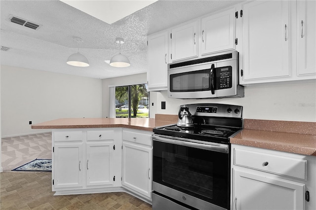 504 Silver Crse Unit A, Ocala, FL 34472 - kitchen featuring stainless steel appliances, a peninsula, white cabinets, a textured ceiling, and pendant lighting