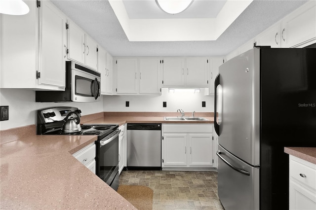 504 Silver Crse Unit A, Ocala, FL 34472 - kitchen with appliances with stainless steel finishes, a sink, white cabinets, a raised ceiling, and stone finish flooring