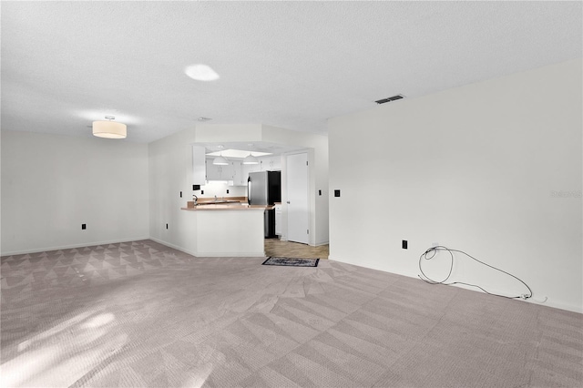 504 Silver Crse Unit A, Ocala, FL 34472 - unfurnished living room featuring light carpet and a textured ceiling