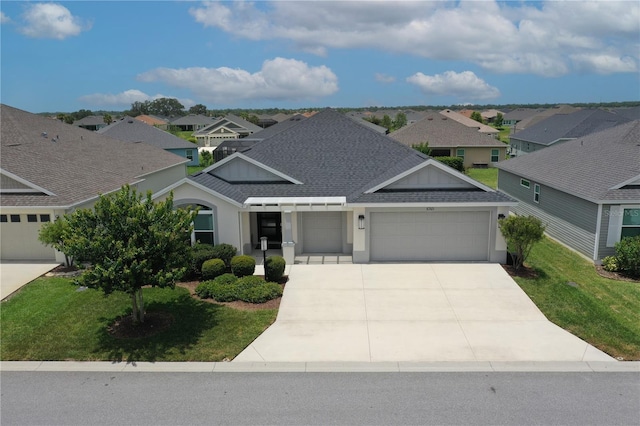 6301 Danielson Loop, The Villages, FL 32163 - view of front of house featuring a shingled roof, an attached garage, concrete driveway, and a front lawn