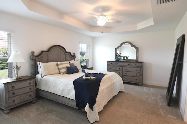 6301 Danielson Loop, The Villages, FL 32163 - bedroom with a tray ceiling, carpet, and a ceiling fan