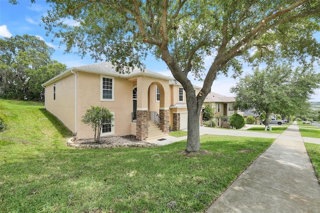 2745 Shearwater St, Clermont, FL 34711 - view of front of house with stucco siding, a front lawn, driveway, a garage, and stone siding