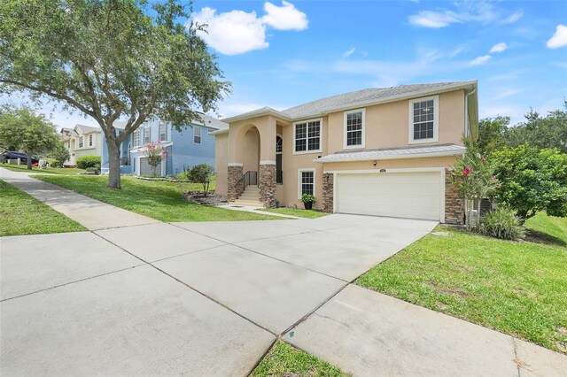 2745 Shearwater St, Clermont, FL 34711 - view of front facade with stucco siding, driveway, a front lawn, a garage, and stone siding