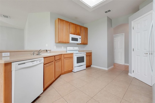 2745 Shearwater St, Clermont, FL 34711 - kitchen with white appliances, light countertops, a peninsula, light tile patterned floors, and arched walkways
