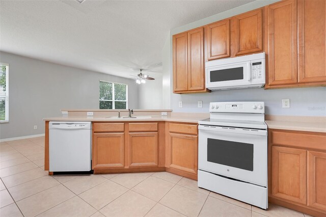2745 Shearwater St, Clermont, FL 34711 - kitchen with white appliances, light countertops, ceiling fan, a peninsula, and light tile patterned flooring