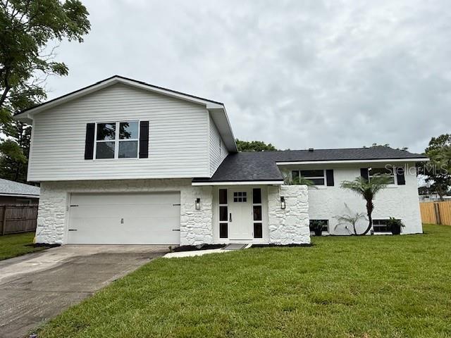 8203 Bluestar Cir, Orlando, FL 32819 - view of front facade featuring an attached garage, stone siding, and driveway