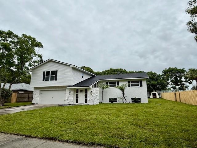 8203 Bluestar Cir, Orlando, FL 32819 - view of front of house with a garage, stone siding, and concrete driveway