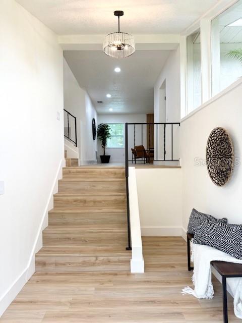 8203 Bluestar Cir, Orlando, FL 32819 - staircase with baseboards, wood finished floors, and recessed lighting