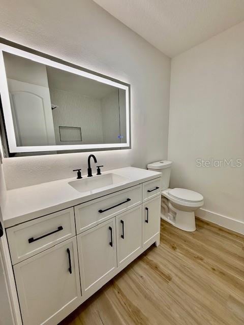 8203 Bluestar Cir, Orlando, FL 32819 - bathroom with wood finished floors, vanity, toilet, and baseboards