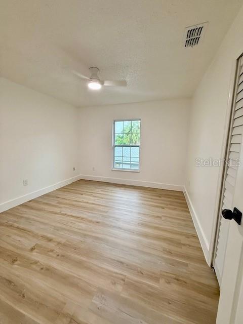 8203 Bluestar Cir, Orlando, FL 32819 - unfurnished room with light wood-style flooring, a ceiling fan, and baseboards