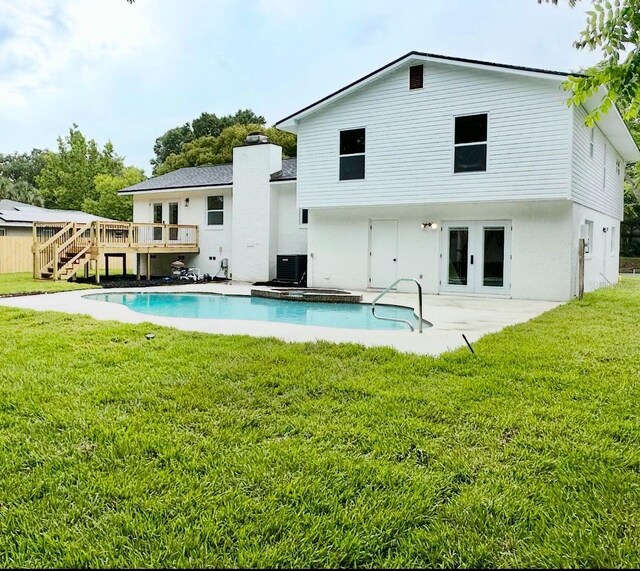 8203 Bluestar Cir, Orlando, FL 32819 - rear view of property with a deck, french doors, a lawn, stairs, and a chimney