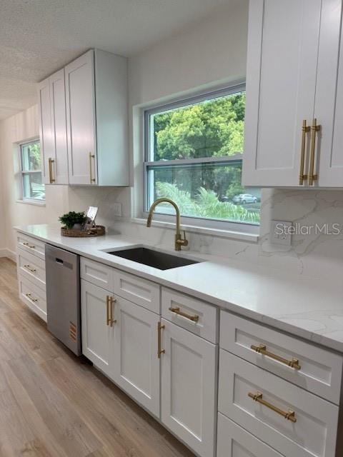 8203 Bluestar Cir, Orlando, FL 32819 - kitchen with dishwasher, a sink, light wood-style flooring, and healthy amount of natural light