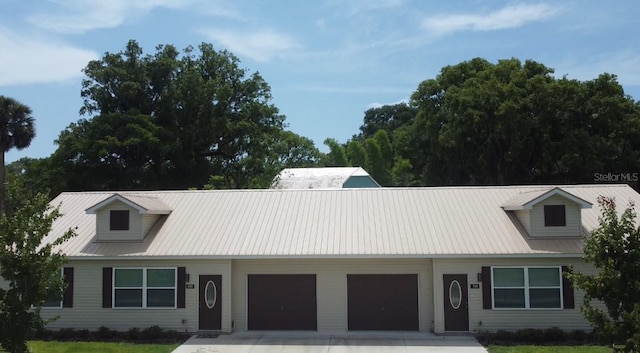 501 N Simpson St, Mount Dora, FL 32757 - view of front facade featuring an attached garage, driveway, a front yard, and a metal roof