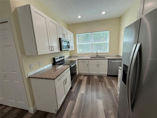 501 N Simpson St, Mount Dora, FL 32757 - kitchen with stainless steel appliances, dark wood-style floors, white cabinetry, recessed lighting, and a textured ceiling