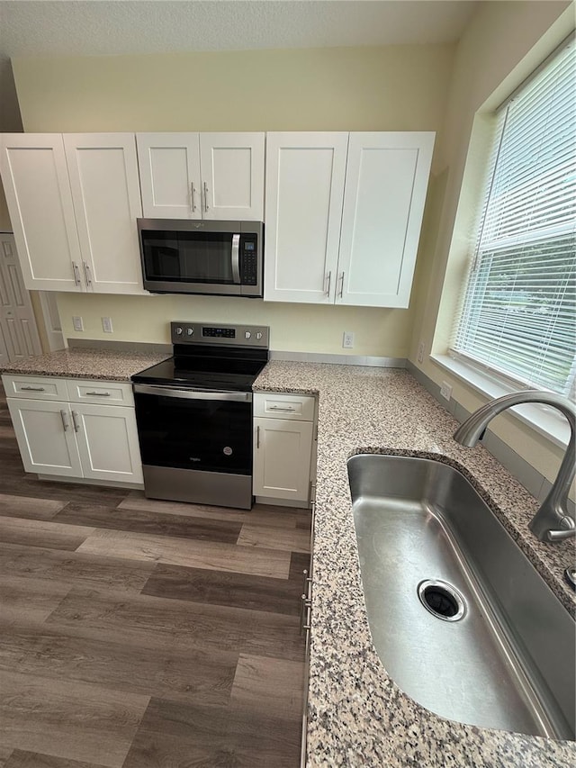 501 N Simpson St, Mount Dora, FL 32757 - kitchen featuring stainless steel appliances, white cabinets, and light stone countertops