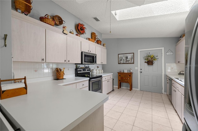 17533 SE 96th Ct, Summerfield, FL 34491 - kitchen featuring stainless steel appliances, light countertops, decorative backsplash, a skylight, and a textured ceiling
