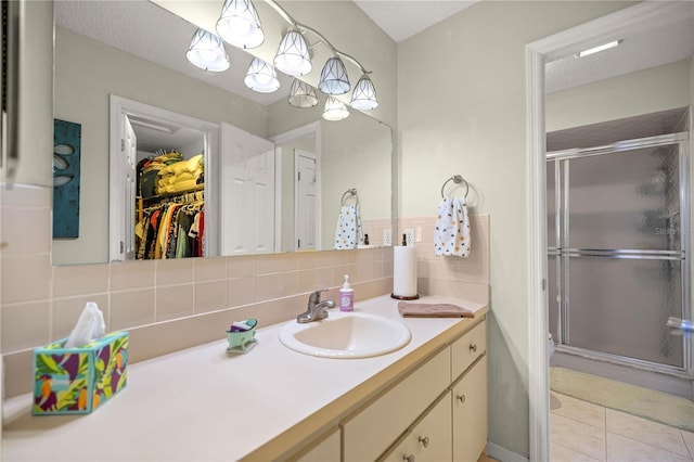 17533 SE 96th Ct, Summerfield, FL 34491 - full bathroom featuring backsplash, vanity, a shower stall, a walk in closet, and tile patterned flooring