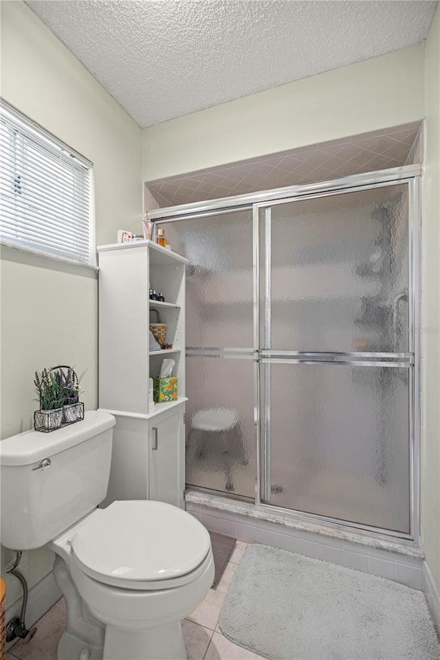 17533 SE 96th Ct, Summerfield, FL 34491 - bathroom with toilet, a shower stall, tile patterned flooring, and a textured ceiling