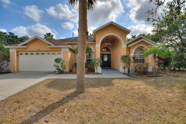 3310 Osprey Hill St, Clermont, FL 34714 - mediterranean / spanish home featuring stucco siding, an attached garage, concrete driveway, and a front lawn