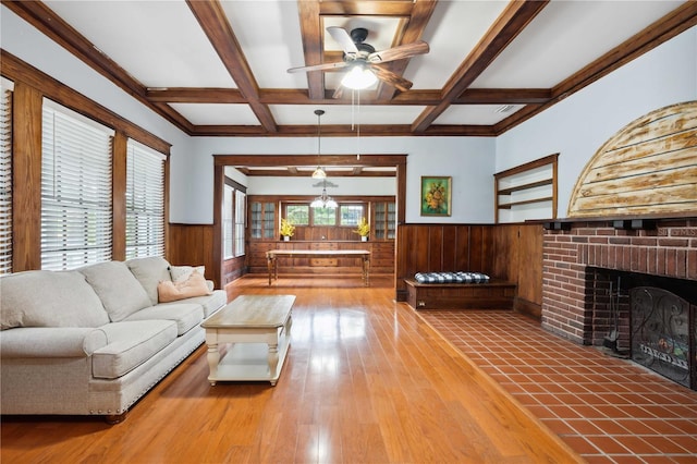 263 NE 1st St, Webster, FL 33597 - living area featuring wainscoting, a ceiling fan, beamed ceiling, hardwood / wood-style floors, and a brick fireplace