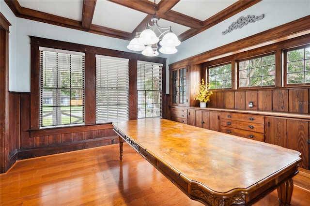 263 NE 1st St, Webster, FL 33597 - dining space with a chandelier, coffered ceiling, wooden walls, beam ceiling, and wood finished floors
