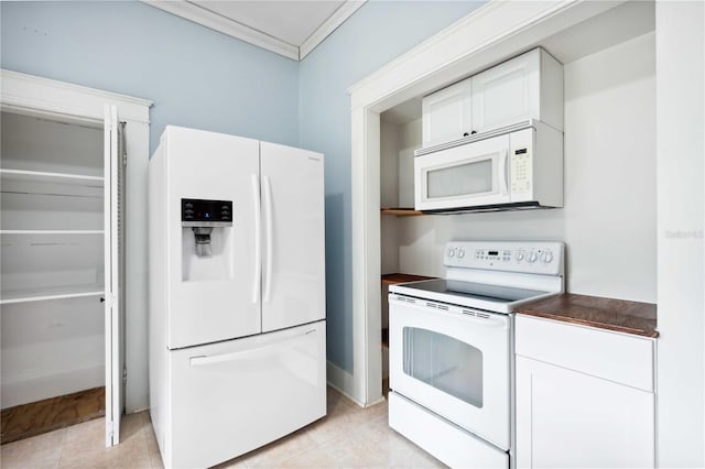 263 NE 1st St, Webster, FL 33597 - kitchen with white appliances, dark countertops, ornamental molding, white cabinets, and light tile patterned floors